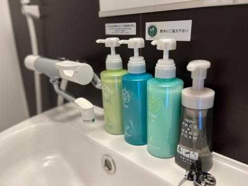 ein Waschbecken mit vier Flaschen Waschmittel darauf in der Unterkunft Hotel Route Inn Kyoto Kameoka in Kameoka