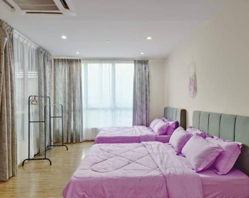 2 Betten in einem Zimmer mit lila Bettwäsche in der Unterkunft SETAPAK CENTRAL KL - Lavender Zetapark Suite in Kuala Lumpur