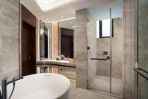 ein Bad mit einer Dusche, einem WC und einem Waschbecken in der Unterkunft Hilton Garden Inn Nujiang in Lushui