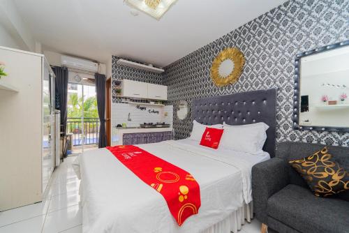 een slaapkamer met een groot bed en een stoel bij RedLiving Apartemen Cinere Resort - Gold Room in Gandul