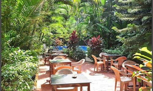 a group of tables and chairs in a garden at FabExpress VT Resort With Pool, Calangute Beach in Calangute