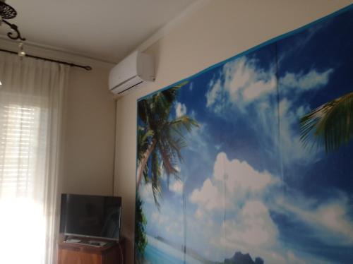 une grande fresque d'un palmier sur un mur dans l'établissement New Dawn Apartment, Appartamento Turistico, casa vacanze, à Catane