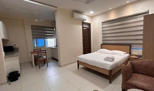 海得拉巴的住宿－FabHotel Prime AM Suites Near Yashoda Hospital，一间卧室配有一张床、一张沙发和一张桌子