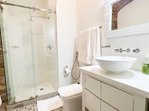 La salle de bains blanche est pourvue d'un lavabo et d'une douche. dans l'établissement Apartamento en el corazón de Casco Viejo Panamá 14, à Panama City