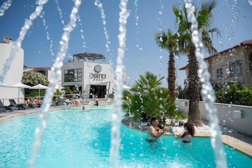 a group of people sitting in a swimming pool at Ostria Sea Side Hotel in Hanioti