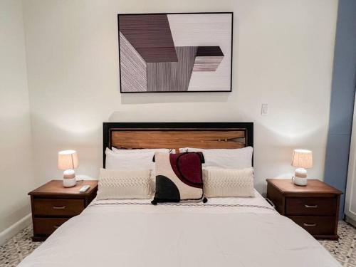 ein Schlafzimmer mit einem großen Bett mit zwei Nachttischen in der Unterkunft Apartamento en el corazón de Casco Viejo Panamá 14 in Panama-Stadt