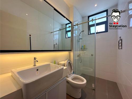 uma casa de banho com um lavatório e um WC em Staycation Homestay 24 Royal Richmond Near Airport em Kuching