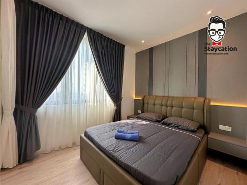 um quarto com uma cama com uma almofada azul em Staycation Homestay 24 Royal Richmond Near Airport em Kuching
