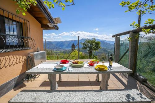 una mesa con platos de comida en el balcón en Petit Cadeau - Happy Rentals, en Cademario