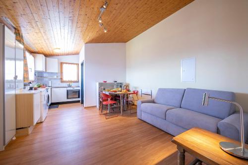 un soggiorno con divano blu e una cucina di Petit Cadeau - Happy Rentals a Cademario