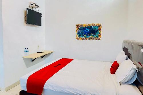 1 dormitorio con 1 cama y una foto en la pared en RedDoorz At Damai Guest House Kabanjahe, en Kabanjahe
