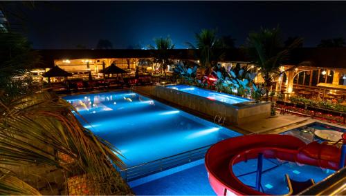 a swimming pool at night with blue lights at Grand Sunshine Resort & Convention in Bandung