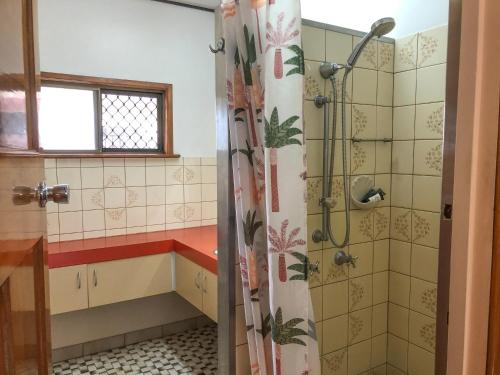 a bathroom with a shower and a tub at Jindy's Cottage Atherton in Atherton