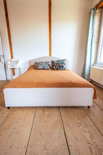 a bed with two pillows on it in a bedroom at La colonie - Haut Valromey in Chavillieu