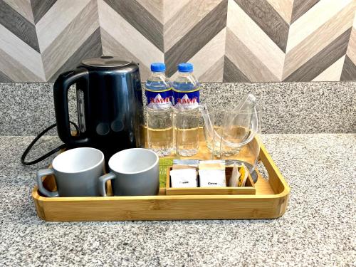 a tray with drinks and cups and bottles of water at Stanford Suites 3 in Silang