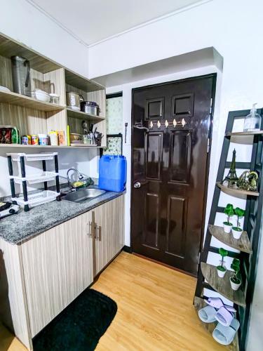 a kitchen with a black refrigerator and a wooden floor at Tiffany's Staycation (Unit 111) in Imus