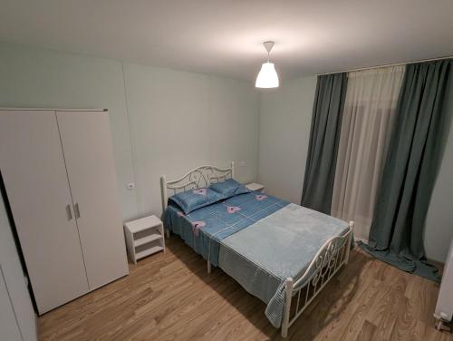 een slaapkamer met een bed met een blauw dekbed bij Sunshine Inn Buriani 