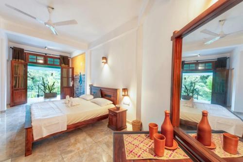a bedroom with two beds and a large window at Sol Y Mar - Unawatuna in Galle