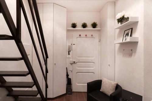 a hallway with a white door and a black chair at [Station - City Center] Studio Flat in Florence