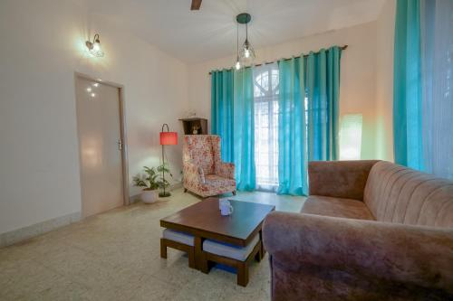 a living room with a couch and a table at HomeSlice Nazaara, HomeStay in BTM in Bangalore