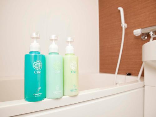 a group of three bottles sitting on a shelf in a bathroom at Hotel Route Inn Grand Chichibu in Chichibu