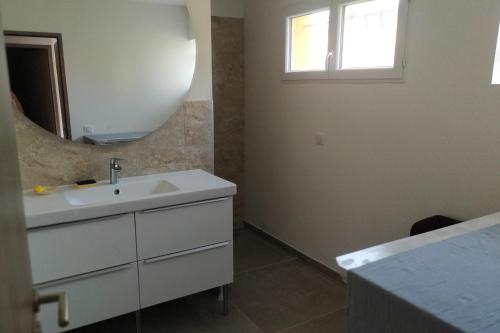 une salle de bain avec un lavabo blanc et un miroir dans l'établissement Pierine, au Lavandou