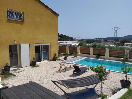 une cour arrière avec une piscine et une maison dans l'établissement Pierine, au Lavandou
