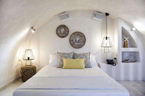 1 dormitorio con 1 cama blanca grande con almohada amarilla en Privée Santorini, en Perissa