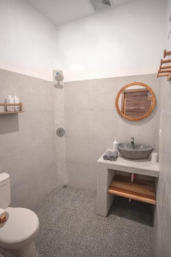 a bathroom with a sink and a toilet and a mirror at My Island Home Gili Air in Gili Air
