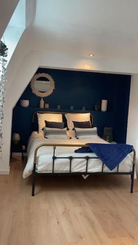 - une chambre dotée d'un lit avec un mur bleu dans l'établissement Maison 6 personnes 3 chambres proche grand stade Pierre mauroy, à Camphin-en-Pévèle