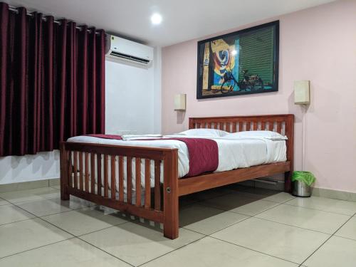 a bedroom with a large wooden bed with red curtains at Green View Executive Stay's in Ernakulam