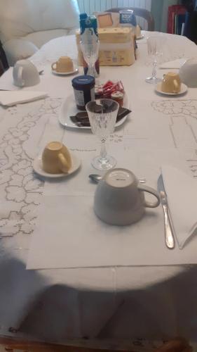 einen langen weißen Tisch mit Tellern und Gläsern darauf in der Unterkunft Residence Claudia in Avezzano