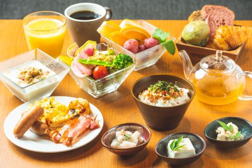 a table topped with plates of food and drinks at KAYA Kyoto Nijo Castle, BW Signature Collection by Best Western in Kyoto