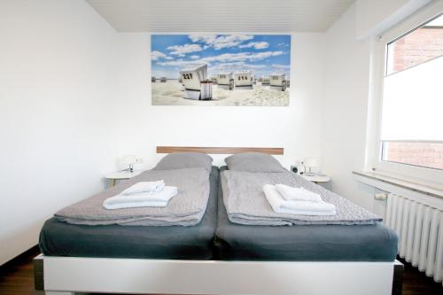 a bedroom with a bed with towels on it at Ferienhaus Pelikanstr 82 Ostermann Bungalow 3 in Norddeich