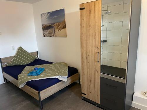 a small bedroom with a bed and a shower at MR Ferienwohnung - Einzelzimmer Frieda in Schellerten