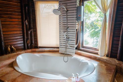 a bath tub in a room with a window at Koh Jum Resort in Ko Jum