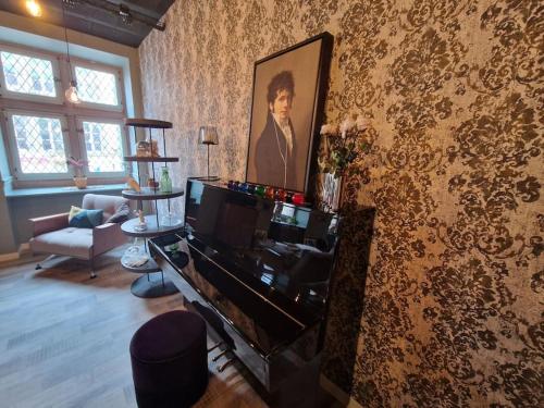 a living room with a piano and a painting on the wall at O centre in Saint-Avold