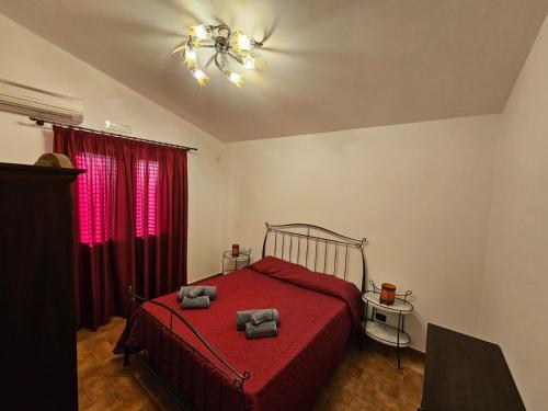 a bedroom with a red bed with two towels on it at Case Magliolo in Cefalù