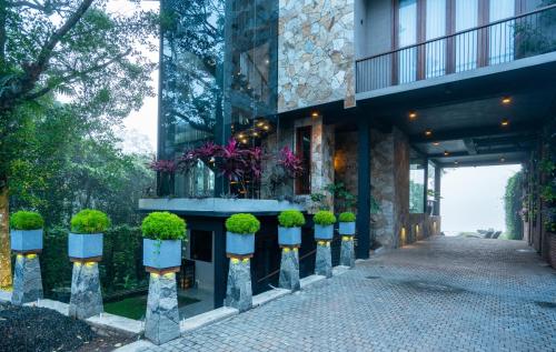 a building with potted plants on the side of it at Kurokawa Kalutara in Kalutara