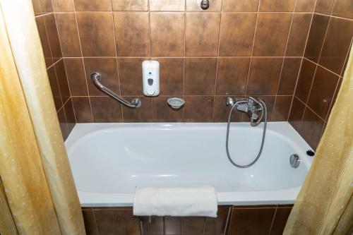 een badkamer met een bad en een telefoon aan de muur bij Majerik Hotel in Hévíz