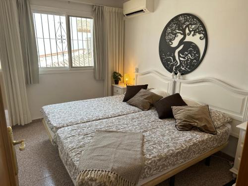 a bedroom with a bed with a large picture on the wall at Right by the pool area in Capistrano Village! in Nerja