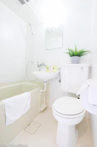 a white bathroom with a toilet and a sink at NEW!Shibuya Prime Unit, near Shibuya Sky & Hachiko in Tokyo