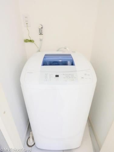 a white washing machine sitting in a room at NEW!Shibuya Prime Unit, near Shibuya Sky & Hachiko in Tokyo