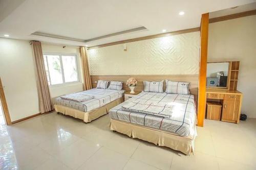 1 dormitorio con 2 camas y mesa con espejo en Phương Đông Hotel, en Sầm Sơn