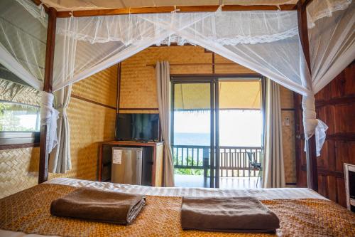 a bedroom with a bed with a large window at Koh Jum Resort in Ko Jum
