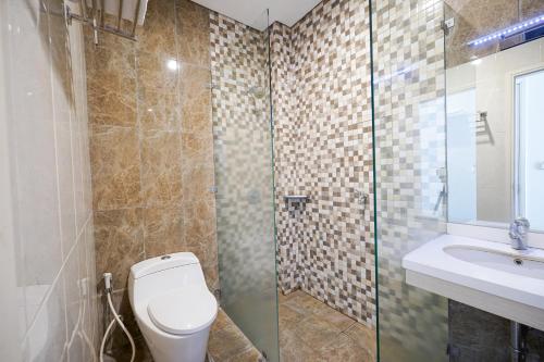 een badkamer met een toilet, een douche en een wastafel bij Multi 88 Syariah in Jakarta