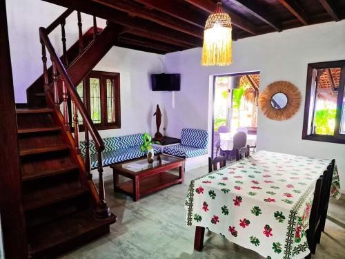 a living room with a table and a staircase at VILLA AMNESYA NOSY BE in Nosy Be