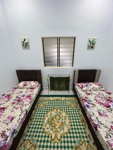 sypialnia z 2 łóżkami i oknem w obiekcie Teratak Cikgu Din w mieście Marang