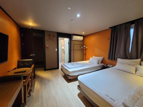 Pokój hotelowy z 2 łóżkami i biurkiem w obiekcie Foxy Hotel w Pusanie