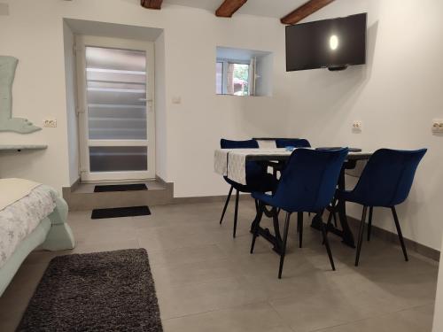 una sala da pranzo con tavolo e sedie blu di Camera de familie a Vatra Dornei